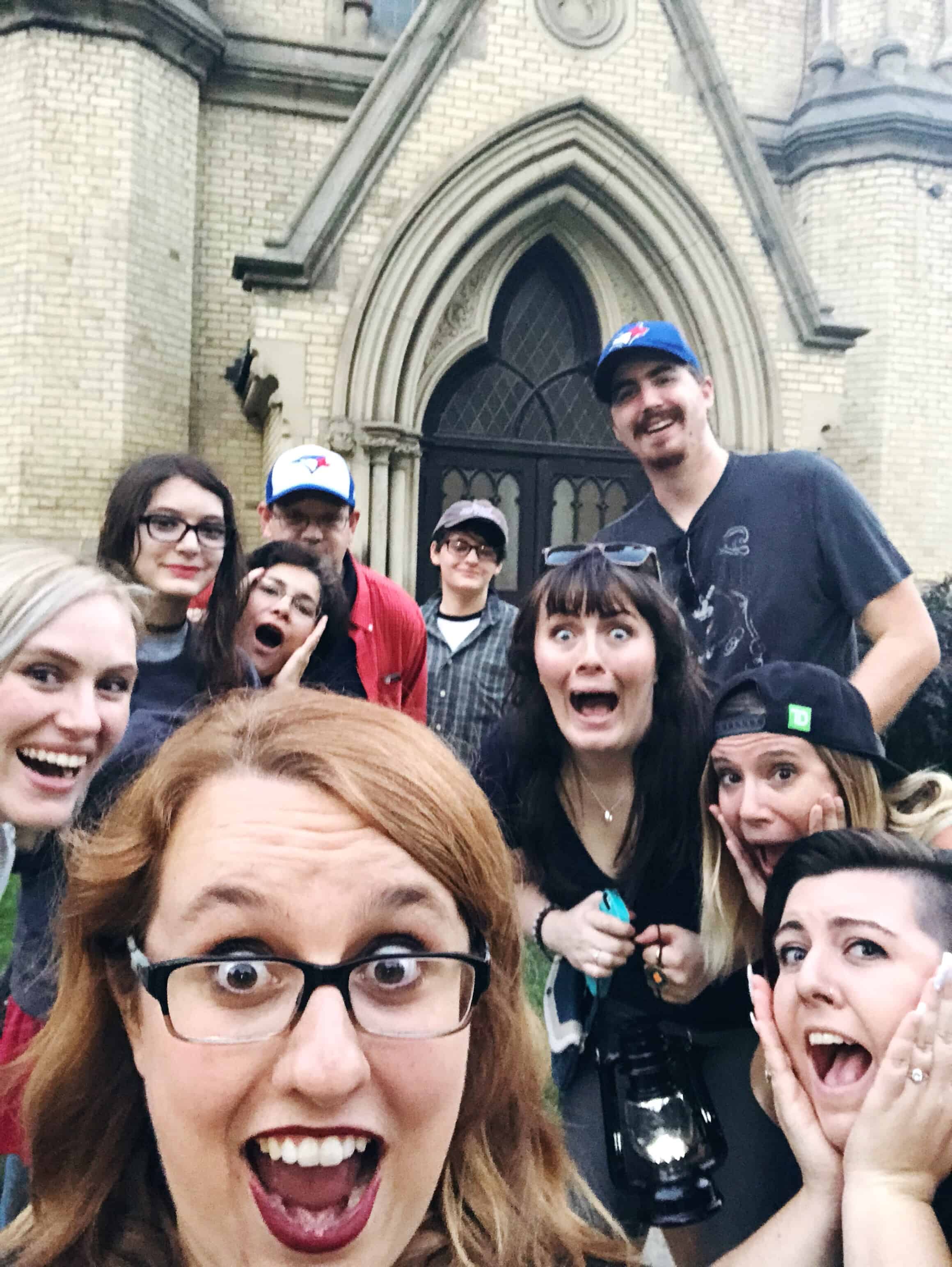 A selfie of 9 people in front of a church